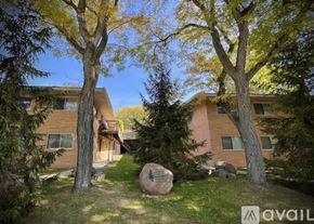 Saline apartment for rent - A large rock sits in the grass in front of a building.