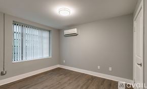 Highland Park apartment for rent - A room with a window, wooden floor, and an air conditioner.