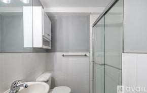 Highland Park apartment for rent - A white bathroom with a glass shower door.