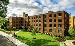 Highland Park apartment for rent - A large brick building with a green lawn in front.