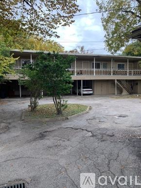 Houston apartment for rent - A tree in front of a building with a sign that says "avail".