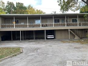 Houston apartment for rent - A car is parked in a parking lot in front of a two-story apartment building.