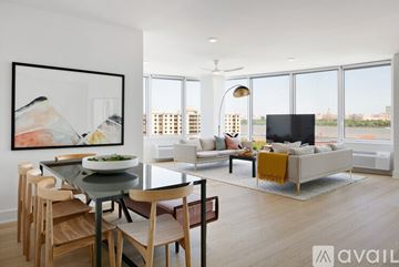 North Bergen condo for rent - A modern living room with a glass table and chairs, a sofa, and a television.