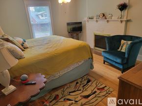 St. Joseph house for rent - A bedroom with a bed, chair, and fireplace.