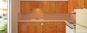 Dallas apartment for rent - A kitchen with wooden cabinets and a white refrigerator.
