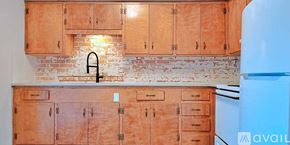 Dallas apartment for rent - A kitchen with wooden cabinets and a brick backsplash.