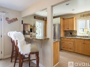 El Segundo apartment for rent - A kitchen with a bar stool and a chair with a white fluffy cushion.