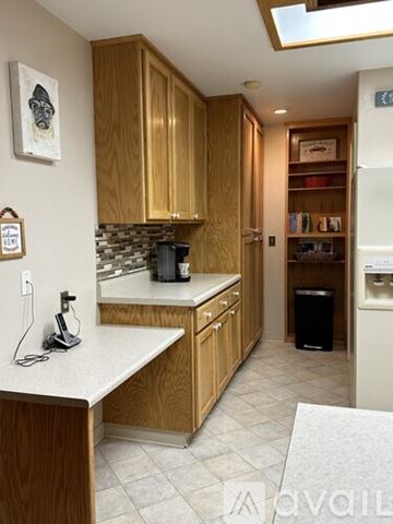 Mariposa house for rent - A kitchen with wooden cabinets and a white countertop.