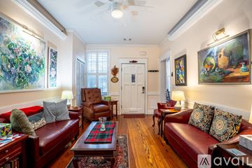 Savannah house for rent - A living room with a red couch and a painting on the wall.