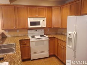 Seattle apartment for rent - A kitchen with wooden cabinets and a white refrigerator.