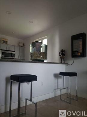 Miami house for rent - Two black stools are in front of a white wall.