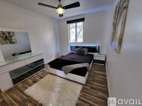 Miami house for rent - A bedroom with a bed, dresser, and a ceiling fan.