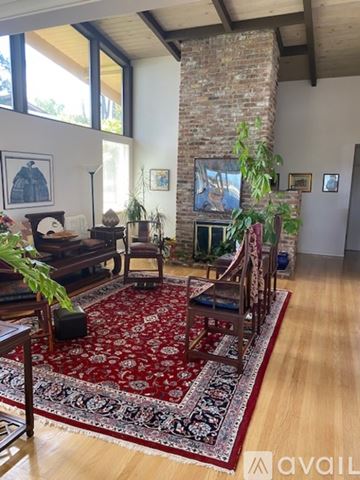 Berkeley apartment for rent - A living room with a red rug and a fireplace.