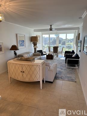 Fort Myers condo for rent - A living room with a white sofa, a wooden side table, and a rug.