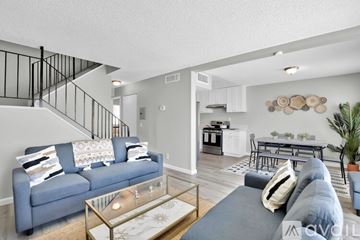 Indio apartment for rent - A living room with a blue couch and a glass coffee table.