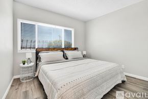 Indio apartment for rent - A bedroom with a large bed and a window with blinds.