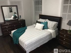 Tampa apartment for rent - A bedroom with a bed, nightstand, and a mirror.