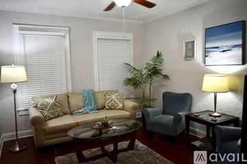 Tampa apartment for rent - A living room with a couch, chair, and a table with a lamp on it.