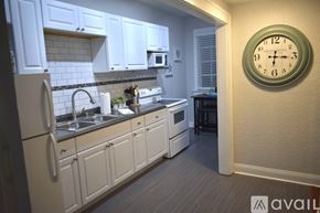 Tampa apartment for rent - A kitchen with white cabinets and a clock on the wall.
