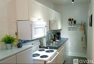 Tampa apartment for rent - A kitchen with white cabinets and a white fridge.