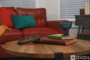 Tampa apartment for rent - A red couch with a blue vase on a wooden table.