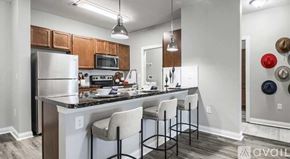 Powell apartment for rent - A kitchen with white cabinets and a black countertop.