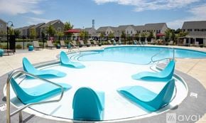 Powell apartment for rent - A round swimming pool surrounded by blue lounge chairs.
