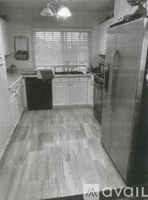 Lake Forest house for rent - A kitchen with a refrigerator, sink, and cabinets.