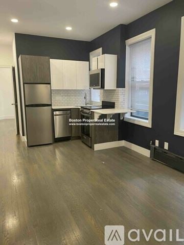 Boston apartment for rent - A kitchen with dark wood floors and a stainless steel refrigerator.