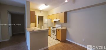 Royal Palm Beach condo for rent - A kitchen with white appliances and wooden cabinets is available for rent.