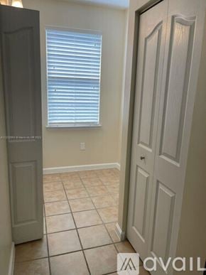 West Palm Beach condo for rent - A room with a door and a window with blinds.