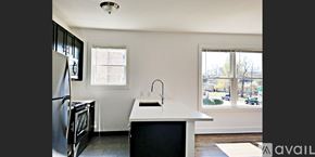 Dallas apartment for rent - A kitchen with a black fridge and a white counter.