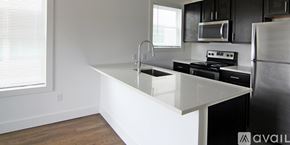 Dallas apartment for rent - A kitchen with a white countertop and black cabinets.