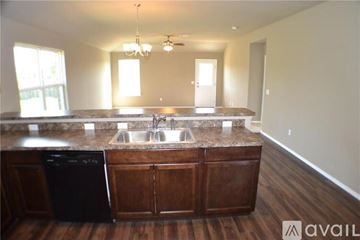 Yukon house for rent - A kitchen with a black dishwasher and wooden cabinets.