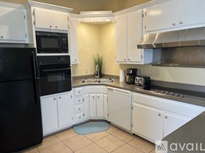 Brownsville apartment for rent - A kitchen with black appliances and white cabinets.