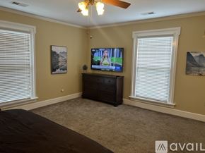 Brownsville apartment for rent - A bedroom with a bed, dresser, and a television playing a show.
