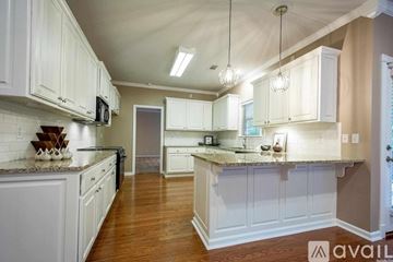 Little Rock house for rent - A kitchen with white cabinets and a granite countertop.