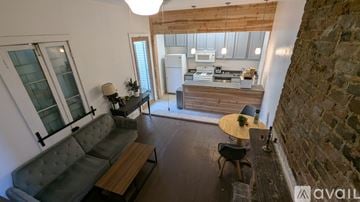 New Orleans house for rent - A living room with a grey couch and a wooden table.