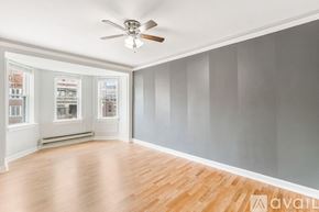 Chicago apartment for rent - A room with a ceiling fan and wooden flooring.