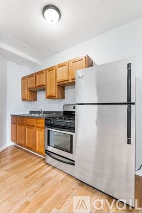 Chicago apartment for rent - A kitchen with a stainless steel refrigerator, oven, and wooden cabinets.