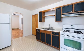 Ambridge apartment for rent - A kitchen with a white fridge, black cabinets, and a white stove top oven.