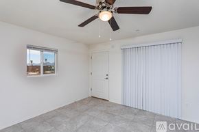Lake Havasu City condo for rent - A room with a ceiling fan and a window with a view of a cityscape.