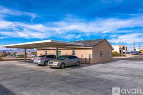 Lake Havasu City condo for rent - A parking lot with a building and two cars parked in front.