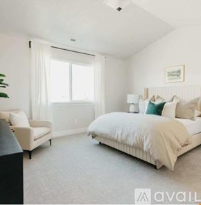 Lehi apartment for rent - A bedroom with a large bed and a chair.