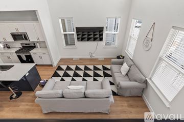 Lehi apartment for rent - A modern living room with a grey sofa and a black and white checkered rug.