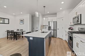 Lehi apartment for rent - A modern kitchen with white cabinets and a wooden floor.