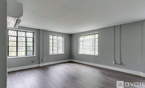 Highland Park apartment for rent - A spacious room with wooden floors and two windows.