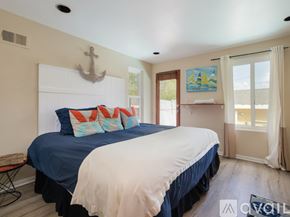 El Segundo townhouse for rent - A bedroom with a large bed and a painting on the wall.