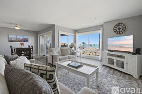 Oceanside apartment for rent - A living room with a large window overlooking the beach.