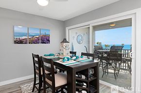 Oceanside apartment for rent - A dining room with a table set for four and a view of the beach.